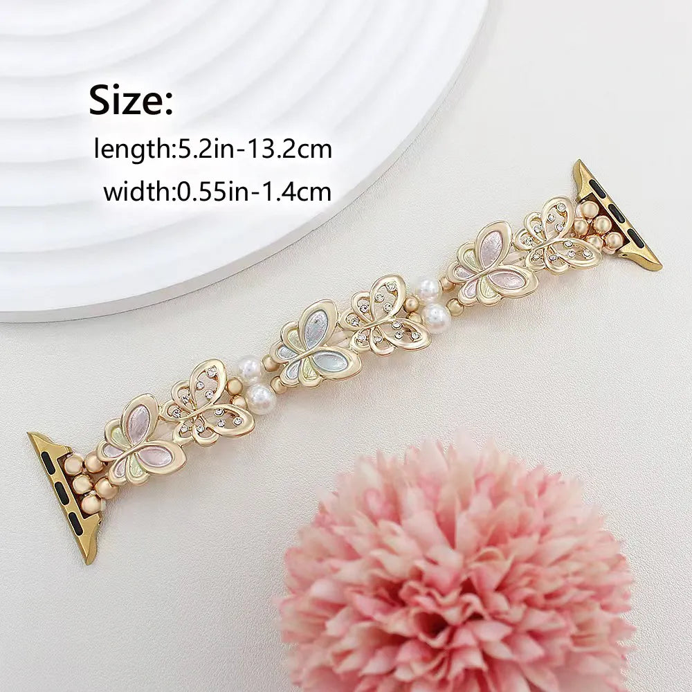 Decorative watch strap with butterfly and pearl design on a white background with a pink flower.