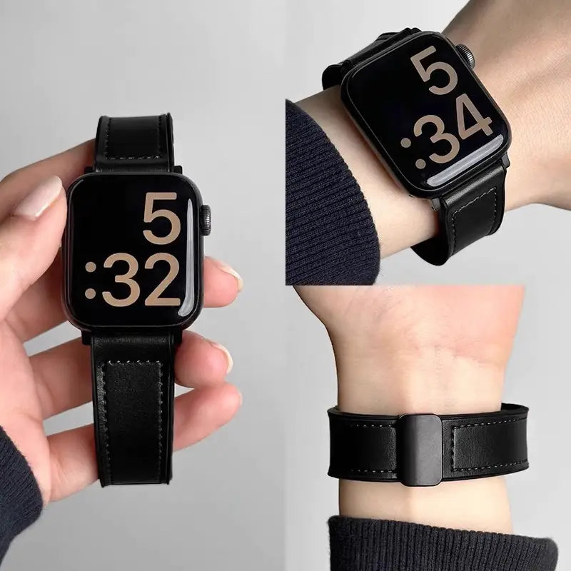 Black smartwatch with leather strap held in hand and worn on wrist against a gray background