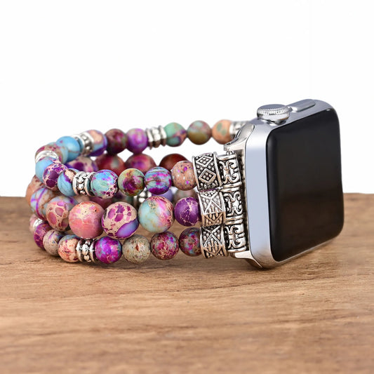 Beaded bracelet with a decorative clasp on an Apple Watch against a wooden background