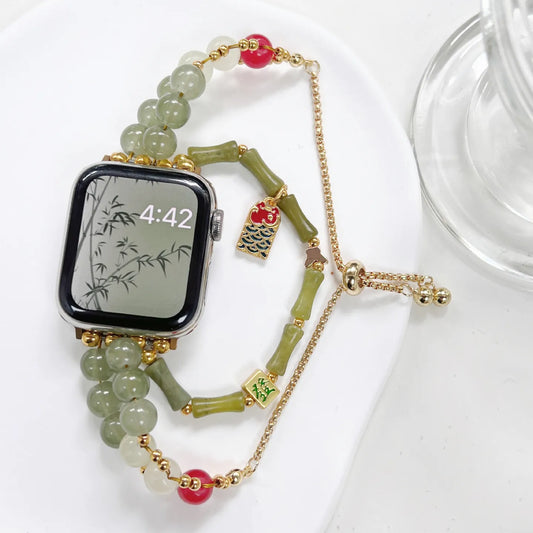 Smartwatch with a decorative bamboo-themed band on a white surface