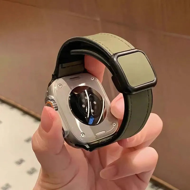 Smartwatch with a green band held in a hand against a neutral background