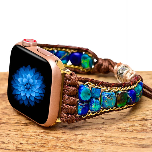 Smartwatch with a decorative brown and blue beaded strap on a wooden surface