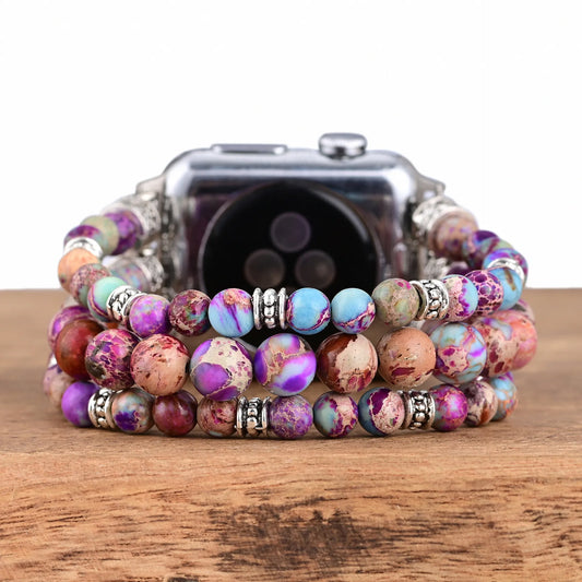 Set of colorful beaded bracelets on a wooden surface with a smartwatch.