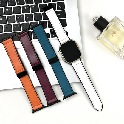 Set of colorful watch straps on a laptop keyboard with a perfume bottle in the background