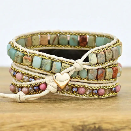 Multistrand beaded bracelet with heart charm on a wooden surface