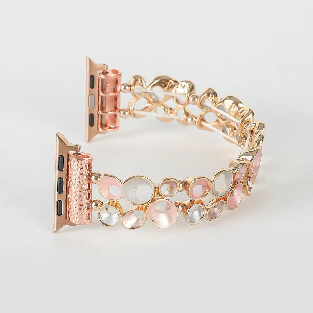 Rose gold watch band with decorative links on a light gray background