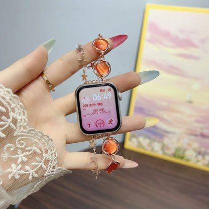 Smartwatch with decorative band held by a hand wearing a lace sleeve.