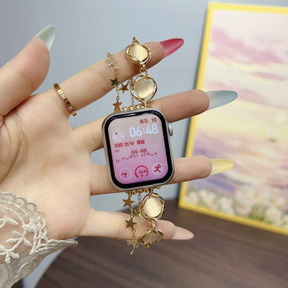 Smartwatch with decorative charm held by a hand against a blurred background