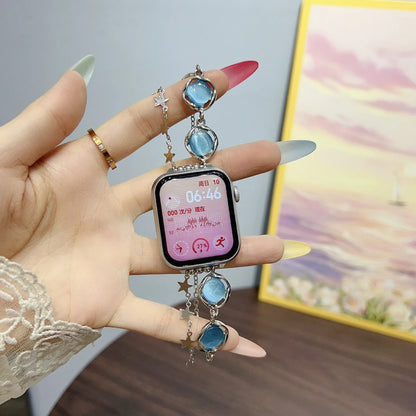 Smartwatch with decorative band held by a hand against a blurred background