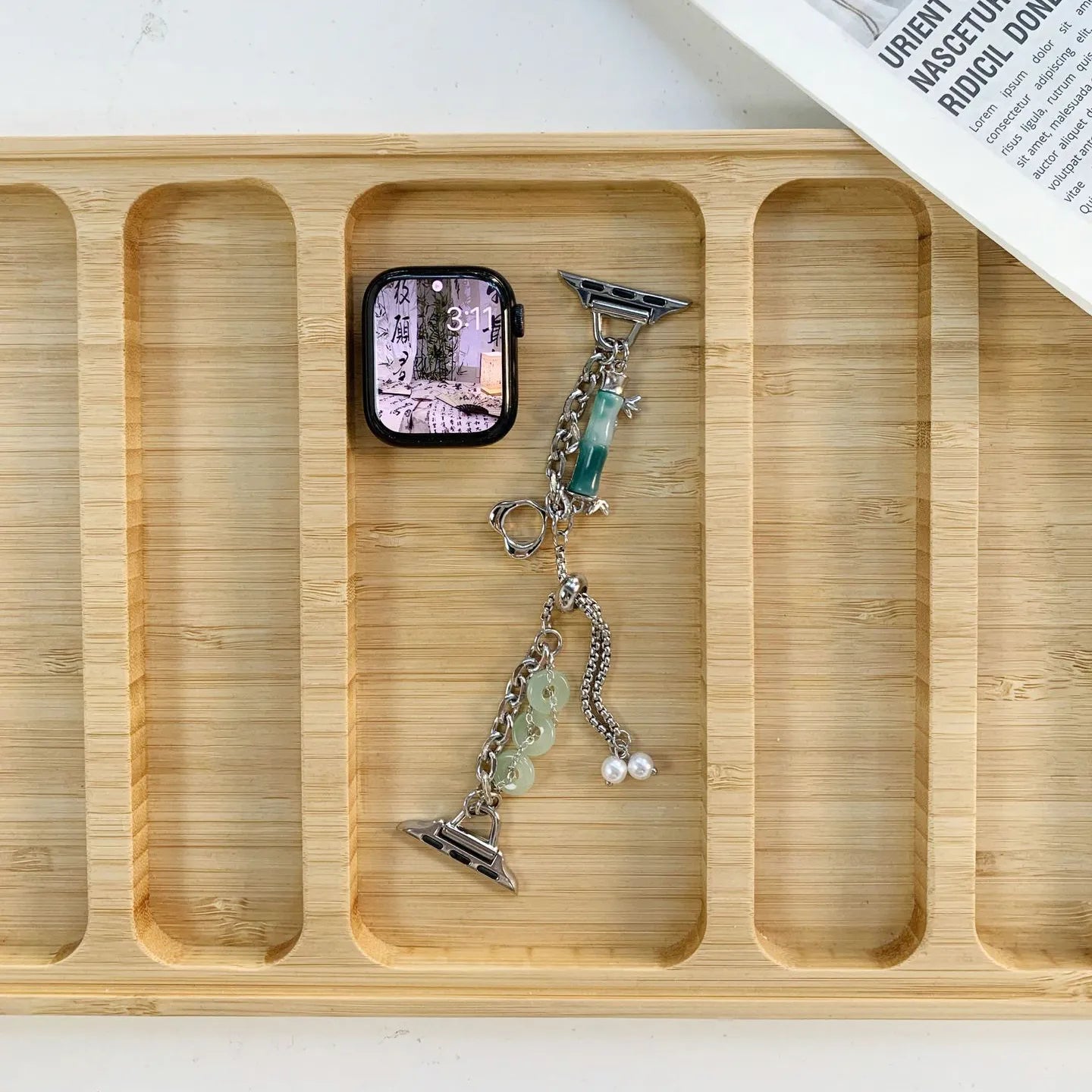 Wooden tray with an Apple Watch and a keychain on a white surface