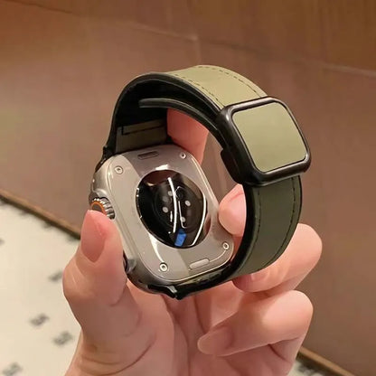 Smartwatch with a green band held in a hand against a neutral background