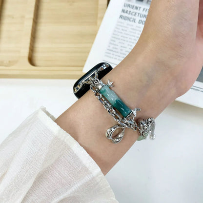 Bracelet with charms on a wrist against a light background