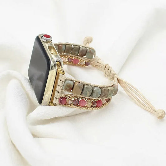 Smartwatch with a decorative band featuring stones and tassel on a white background